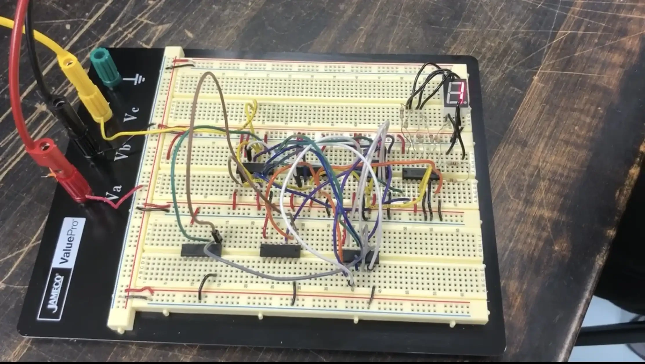 Breadboard with 7 IC chips and a seven-segment display.